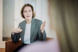 La directora general de la DIHK, Helena Melnikov, discute con una persona en una sala de conferencias. La formación profesional en Alemania: Para quienes buscan oportunidades laborales en Alemania, este aspecto resulta especialmente interesante.