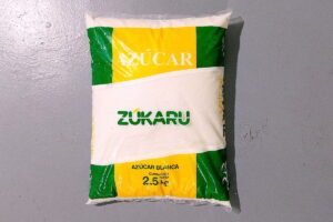 Una bolsa de plástico de 2,5 kg de azúcar cristalino blanco puro «Zúkaru» sobre fondo gris. Alemania frena la ley del impuesto al azúcar por costos y burocracia, aunque preveía 200 empleos en aduanas y cambios en el sector laboral.