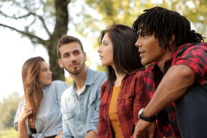 Un grupo de amigos jóvenes conversa de manera distendida y relajada al aire libre. Núremberg acoge el International Community Day: empleo, homologación de títulos, idioma, formación e integración para profesionales internacionales y empresas.